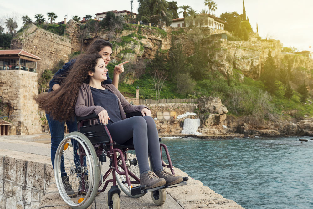 Femme sur un fauteuil roulant accompagnée par une amie